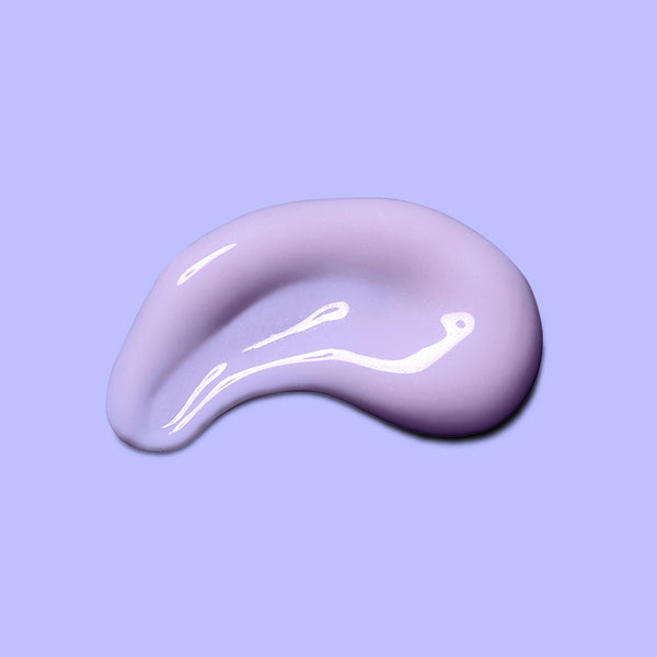 A glossy, smooth smear of light lavender-purple cosmetic cream or gel on a solid light purple background.