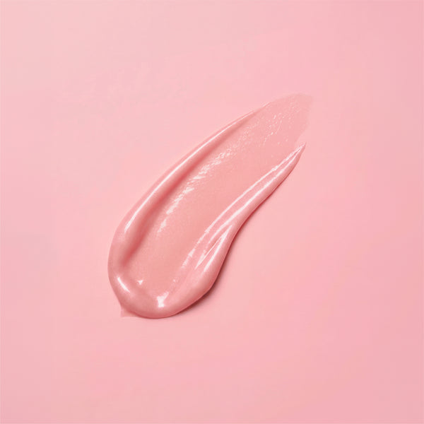 A glossy swirl of pale pink frank body Firming Body Glaze smeared across a soft pink background.