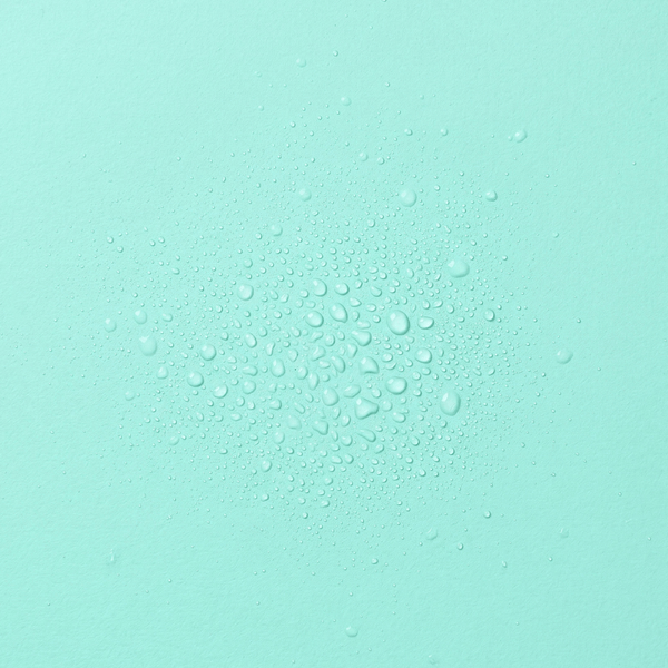 Droplets of frank body Skinny Dip Hair & Body Fragrance Mist on a mint green background.