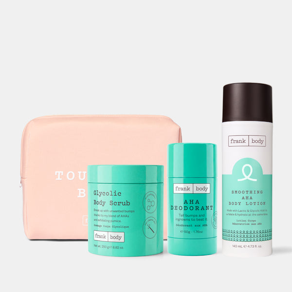 A Frank Body gift set featuring a peach zippered pouch, a mint green Glycolic Body Scrub jar, a mint green AHA Deodorant tube, and a white Shhooming Aha Body Lotion spray can with a dark brown cap, all arranged on a light gray background.