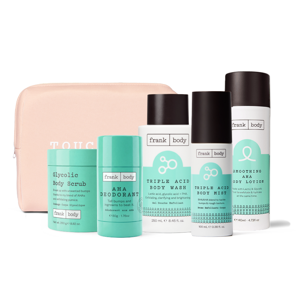 Frank Body body care set including Glycolic Body Scrub, AHA Deodorant, Triple Acid Body Wash, Triple Acid Body Wash, and Handmade Body Lotion, arranged in front of a light pink zippered pouch on a white background.