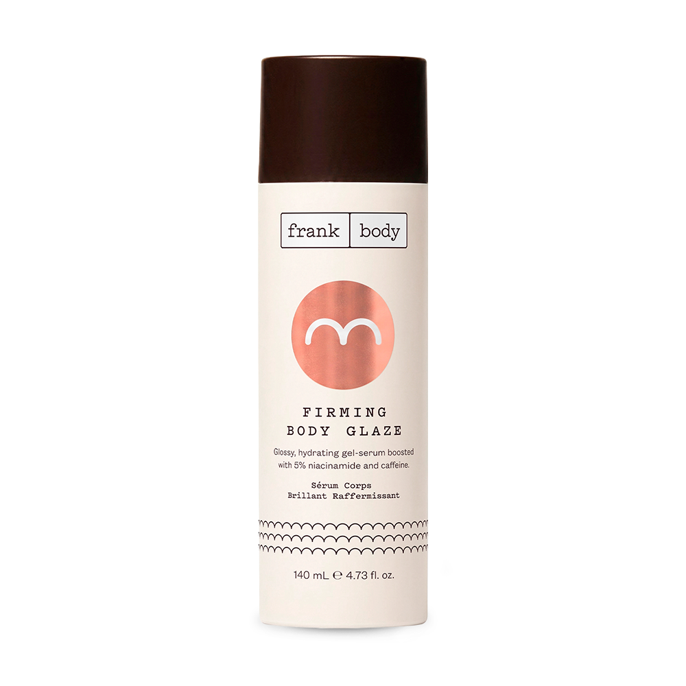 A bottle of frank body Firming Body Glaze serum, featuring a cream-colored label with a metallic rose gold circle logo, black text, and a dark brown cap, set against a plain white background.